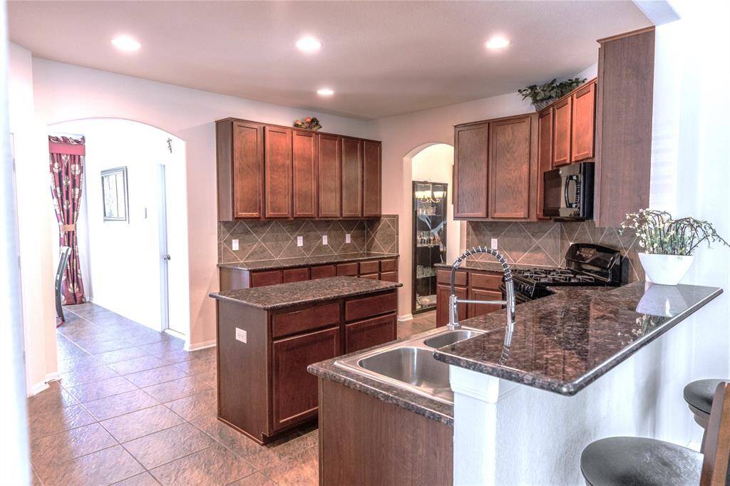 Stylish breakfast bar with sleek countertops, perfect for casual dining and entertaining.