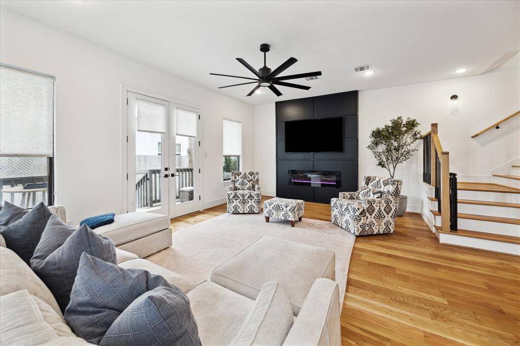 Spacious living room off the kitchen and dining area. Reclaimed hardwood floors, french door access to the patio, beautifully paneled accent wall with new modern electric fireplace.