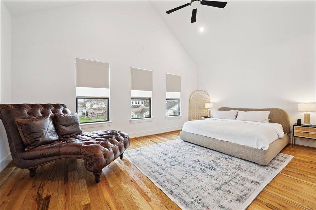 Expansive master suite with reclaimed wood floors, window treatments and sitting area