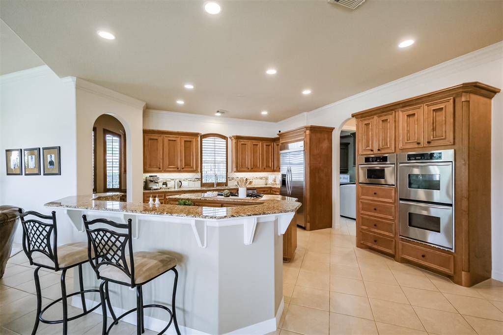 Chef's dream double island kitchen has breakfast bar and gleaming stainless appliances - including double oven and gas cooktop.
