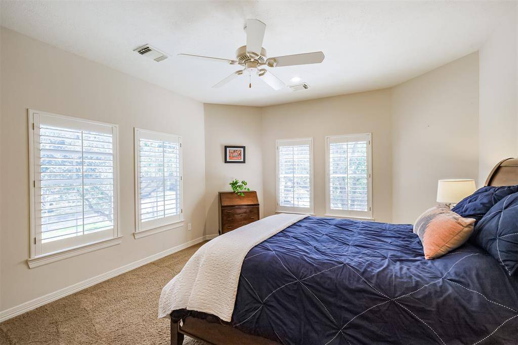 On this wing of the upstairs you will find #3 of 4 secondary bedroom with plantation shutters and ceiling fan.