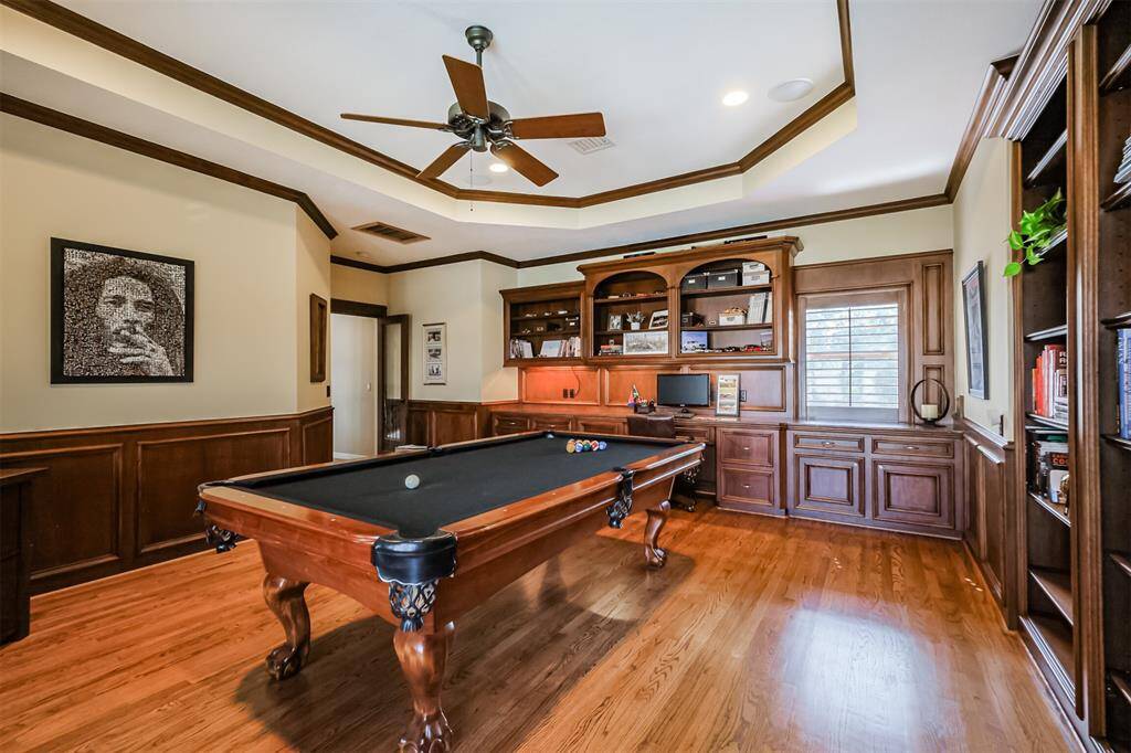 The built-ins on the entry wall have under-cabinet lighting, a desk area and plenty of storage above and below. A granite countertop runs the length of the wall making it the perfect place for food and drinks while enjoying a game of pool.