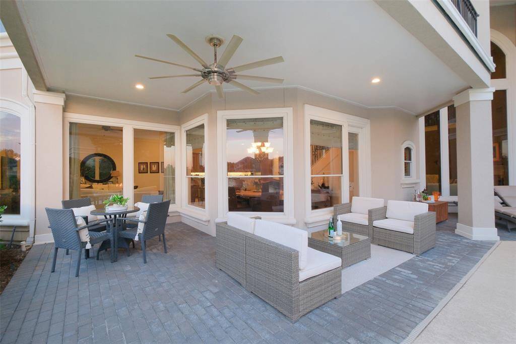 Large covered patio with huge ceiling fan provides space for chatting and dining al fresco year round.