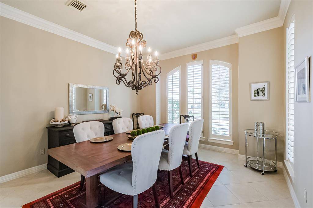 Tiled flooring, double crown molding and two walls of windows with lake views make this the perfect spot for hosting formal dinner parties or large family Holiday gatherings.