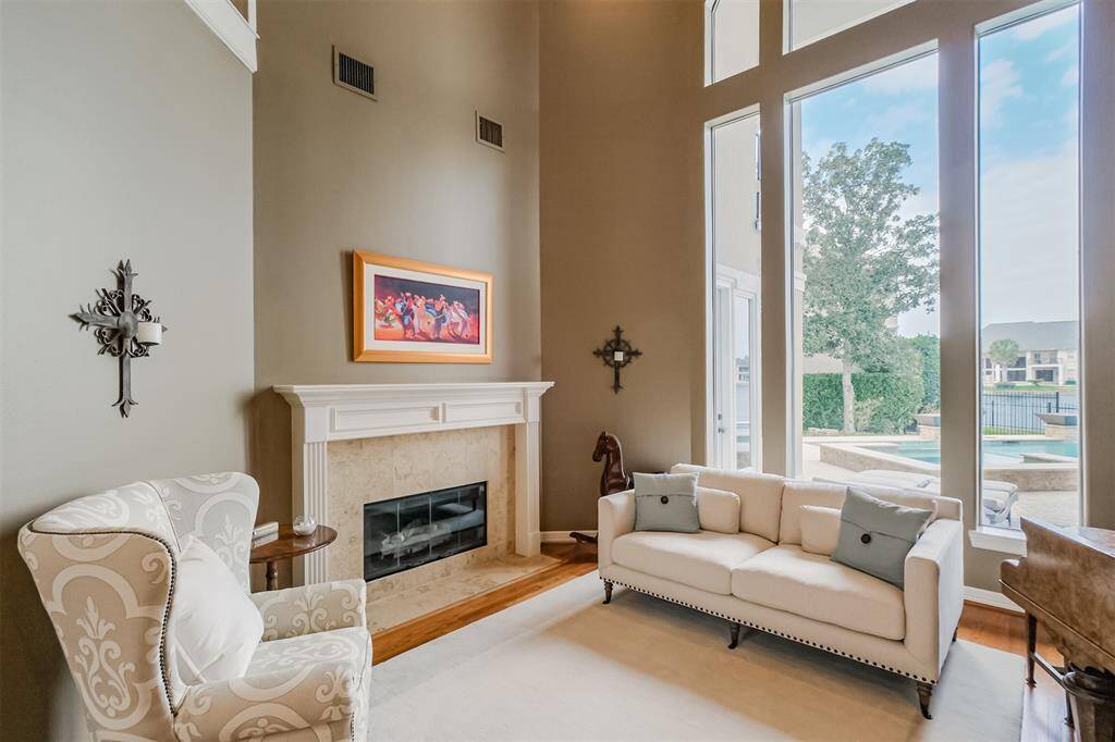 Two story formal living room with amazing pool and lake views - the ideal spot to greet your guests and entertain them with some piano playing before - and after! - dinner.