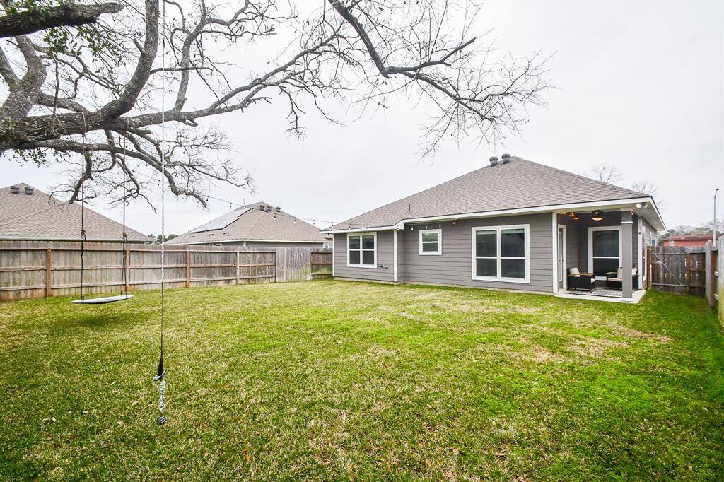 Your future home features a combination of light-colored brick and gray siding, complemented by a dark gray garage door. A small covered porch with a red front door provides a welcoming entrance.