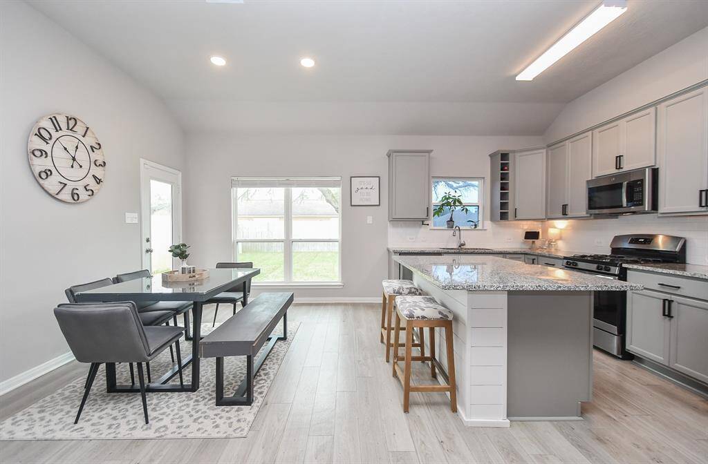 The flooring is light-colored wood laminate, enhancing the bright and airy feel.