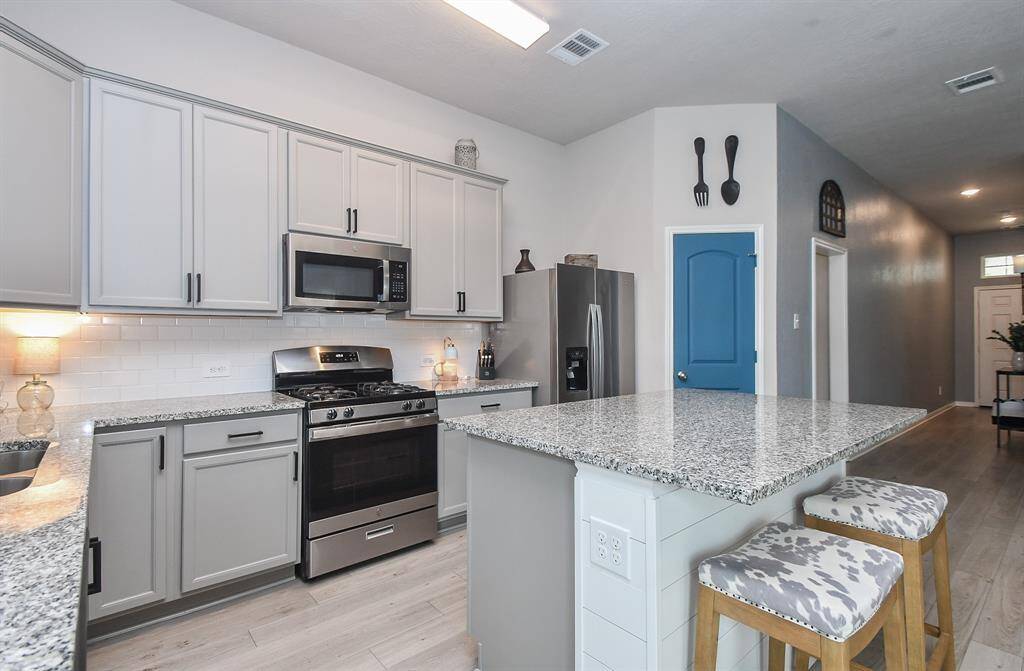 A vibrant blue pantry door adds a pop of color and subtle light colors contribute to the cozy and inviting atmosphere.