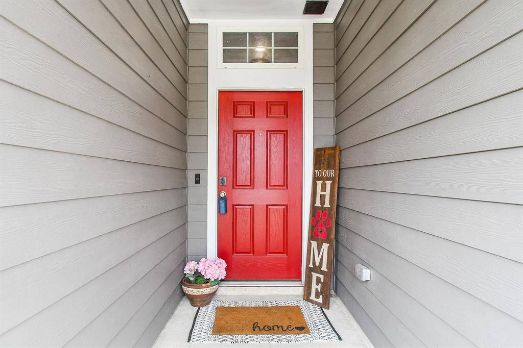 A charming and inviting front entrance featuring a bold red front door