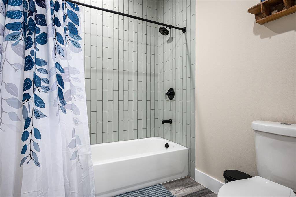 Bath 2: This bathroom has a tub/shower combo and mint green floor-to-ceiling tile.