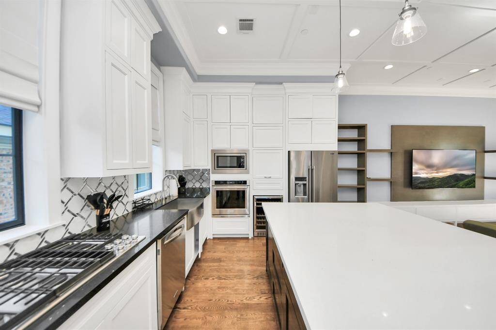 Discover another perspective of this stunning bright kitchen, generously appointed with an abundance of counter space