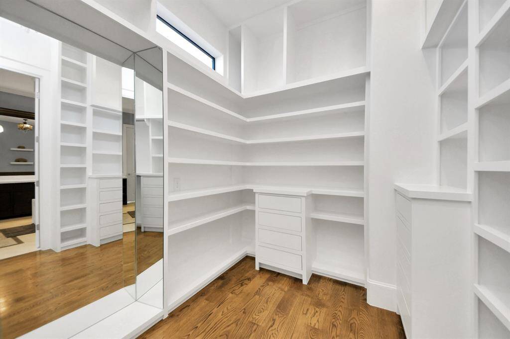 Walk-in closet that epitomizes luxury and practicality. This generously sized space features built-in shelving, offering abundant room for impeccable organization. High ceilings and recessed lighting create a bright and welcoming ambiance.