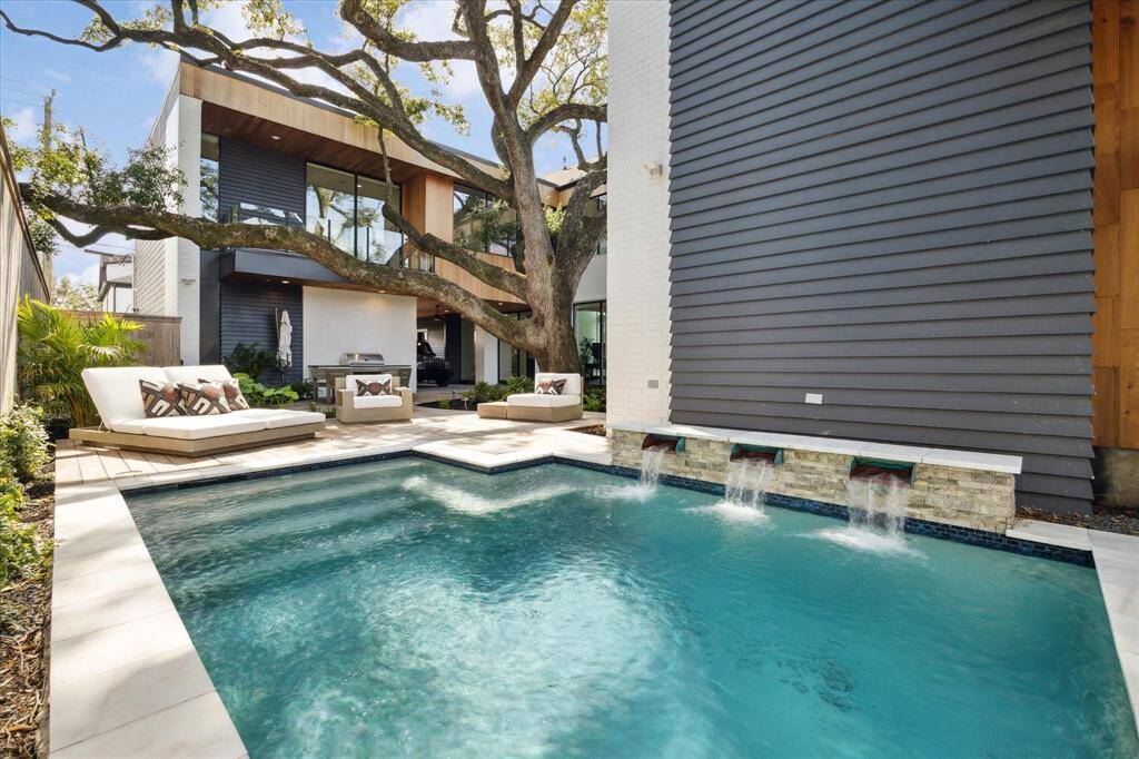The custom 5-foot heated and chilled pool is enhanced by cascading waterfalls and ambient lighting for both day and night enjoyment.