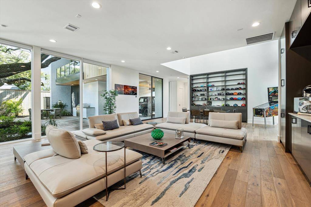 This expansive living and dining room combination offers a perfect blend of comfort and sophistication, featuring floor-to-ceiling windows that bring in natural light and showcase serene views of the outdoor retreat.