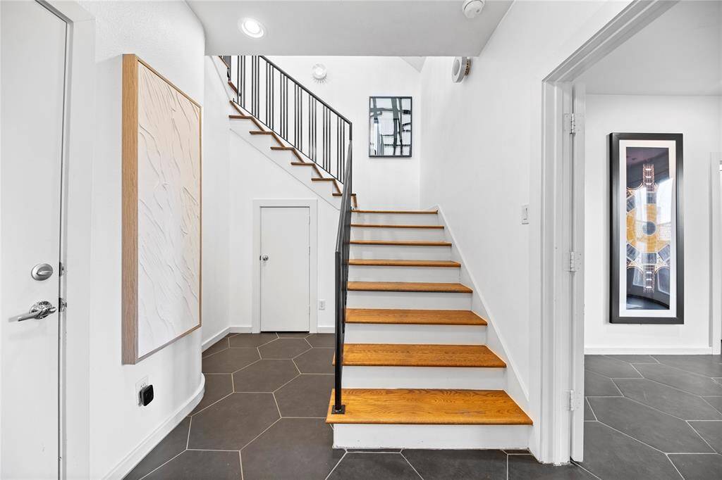Front entry w/ modern large format hexagon tile and under stair storage.