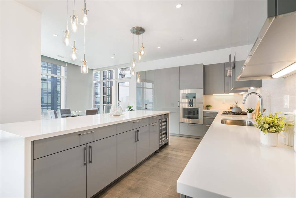 Luminous pendant lighting provide additional light to this bright space! The oversized island provides cityscape views while you prepare delicious meals!