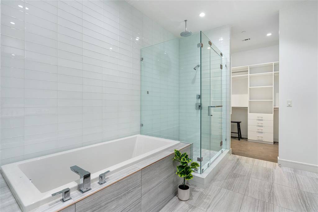 Modern features, such as frameless glass enclosure, and oversized soaking tub, are hallmarks of this beautiful bathroom.