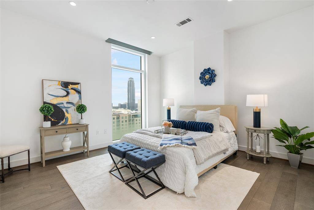 The primary suite boasts high ceilings, neutral paint and views of the Williams Tower!
