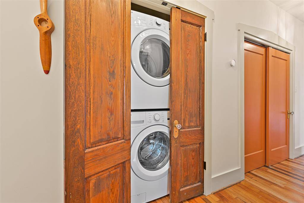 full size washer and dryer located in hallway with stained antique doors