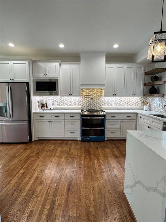 The kitchen features modern custom white cabinetry