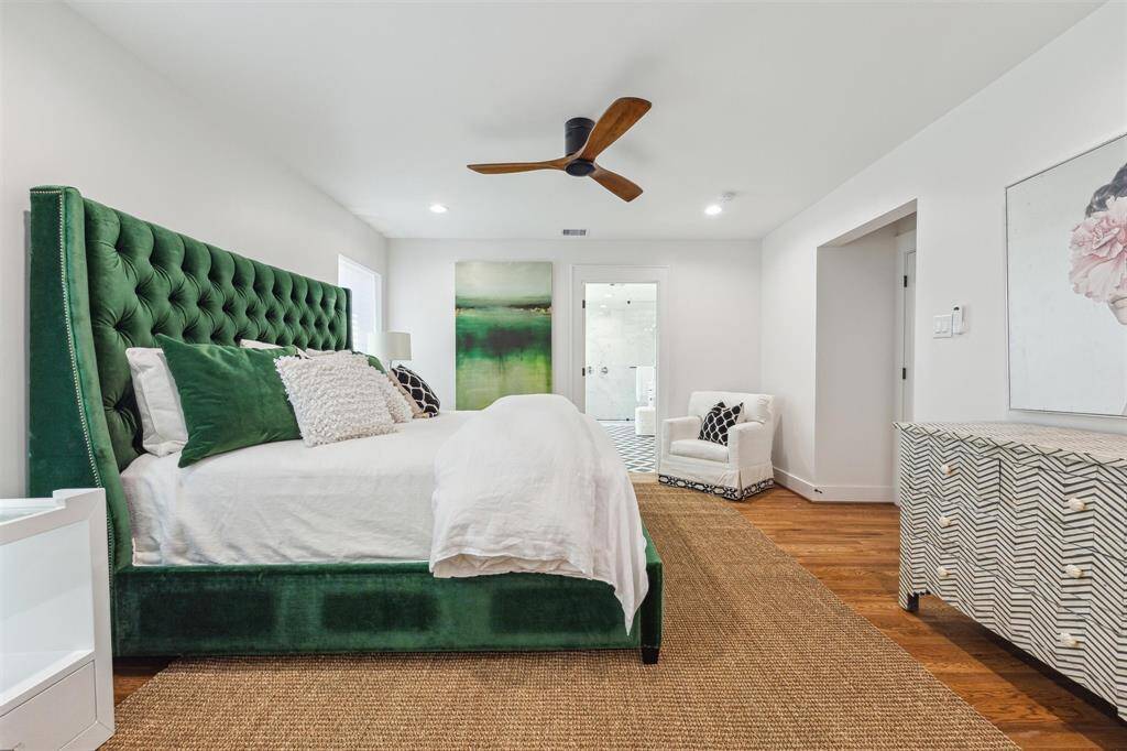 Spacious bedroom, hardwood floors, and a stylish ceiling fan leads to a bright en-suite bathroom.