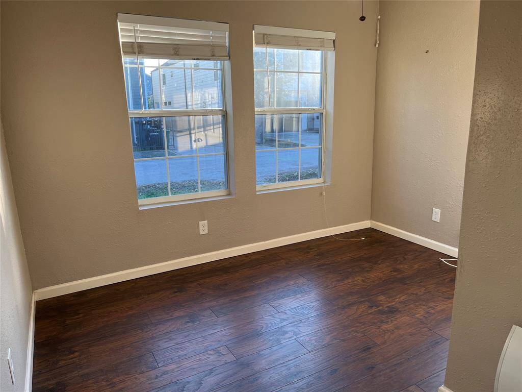 Bedroom two. This room features two large windows allowing ample natural light, neutral wall colors, offering a cozy and inviting space.