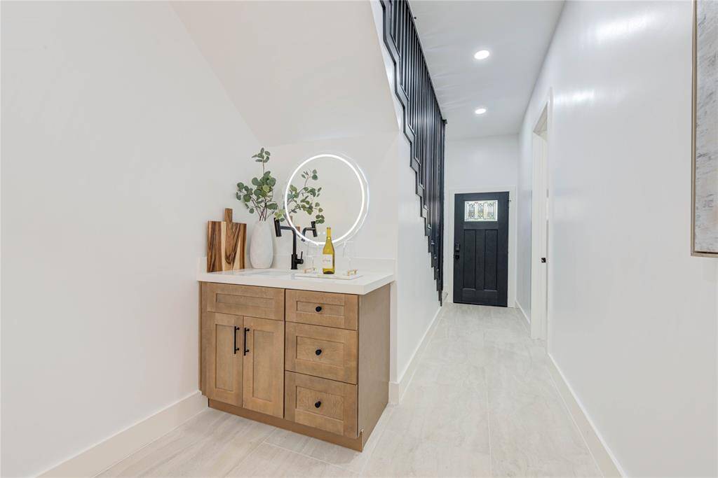 The great room includes a stylish wet bar area with a sink, storage cabinets, and space for a wine cooler, perfect for entertaining guests.