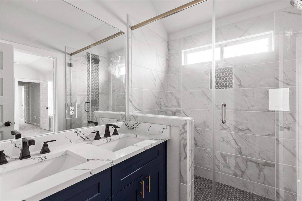 Primary ensuite bathroom, dual sinks and large standing shower.