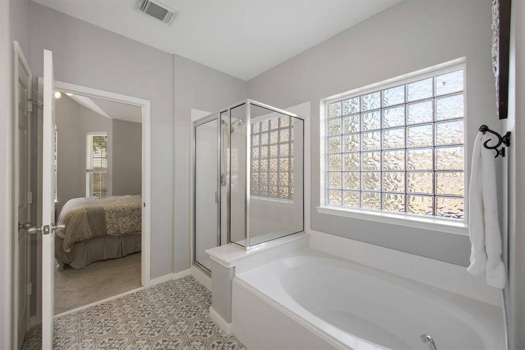The primary ensuite is complete with a relaxing soaking tub and a separate shower, offering the perfect combination of comfort and luxury for a spa-like experience. The oversized closet features two separate doors for easy access.