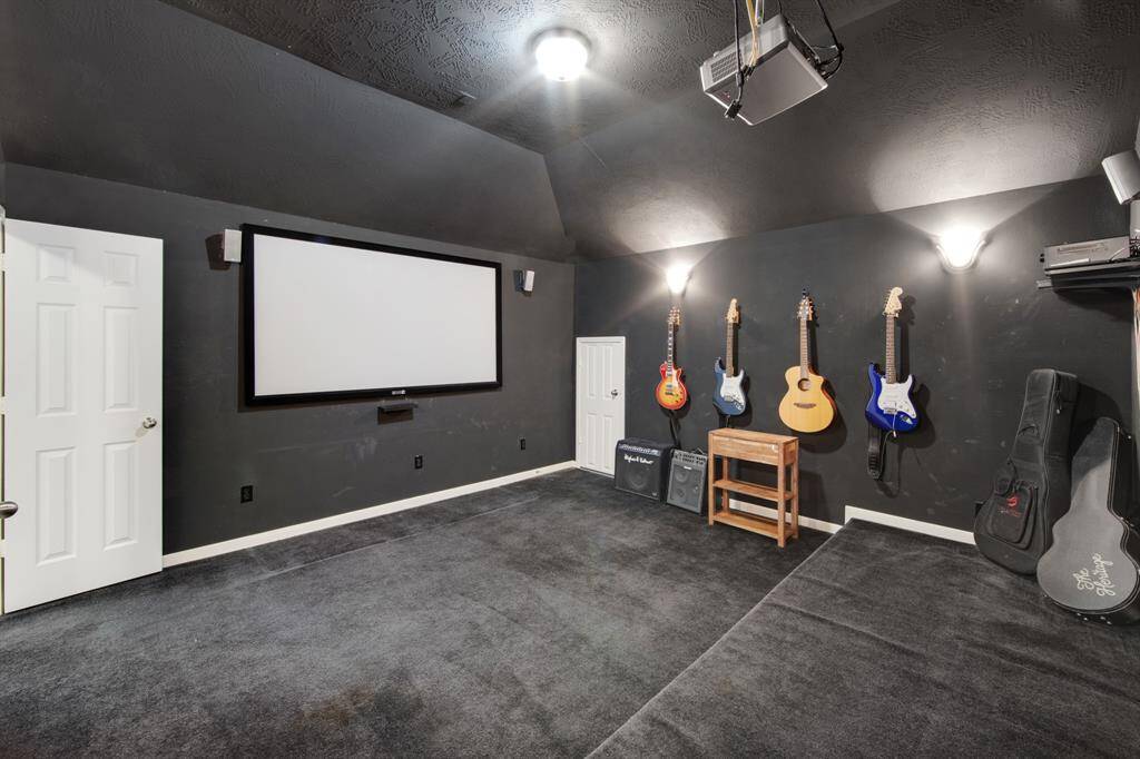 The step-down media room offers an ideal space for movie nights or gaming, providing a cozy, immersive atmosphere. It also includes attic access, adding extra convenience for storage or future customization.