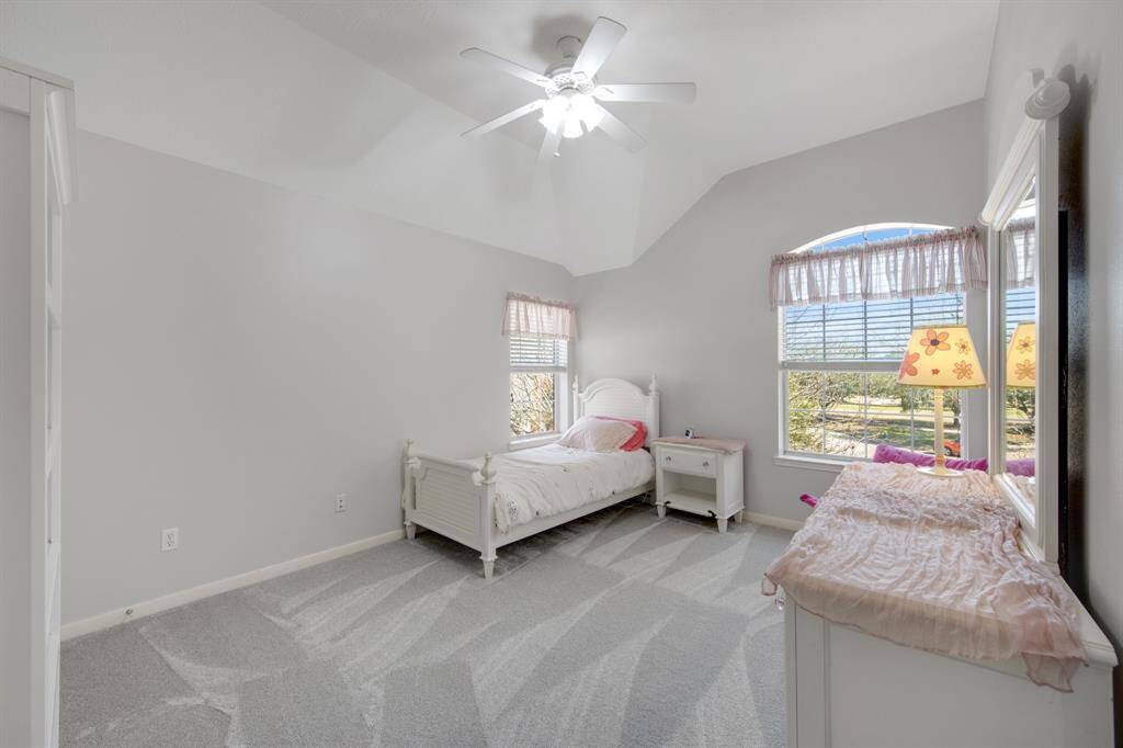 The secondary bedroom is both comfortable and inviting, featuring plush carpeting and a ceiling fan for added comfort and airflow.