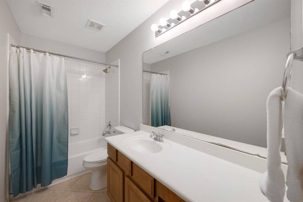 The secondary bathroom features a single vanity and a convenient tub/shower combo, offering both functionality and style for everyday use.