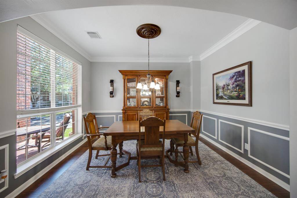 The formal dining room provides an elegant setting for hosting family gatherings, offering ample space for large tables and memorable meals. With its refined wainscoting, crown molding, and inviting views, it creates a perfect atmosphere for celebrating special occasions with loved ones.