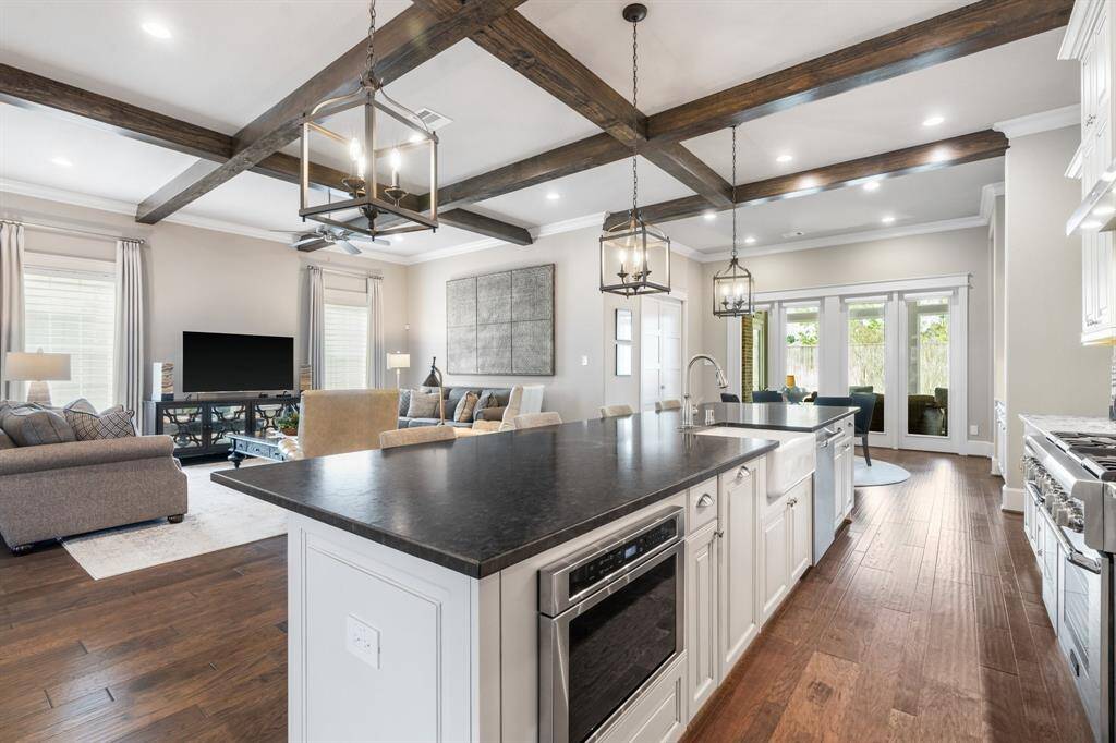 This oversized island offers additional seating, a leathered granite countertop, and large apron undermount sink.