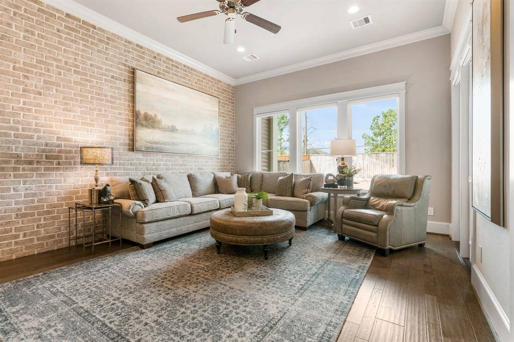 The first floor flex space or "parlor" also features a brick accent wall adding a touch of charm.