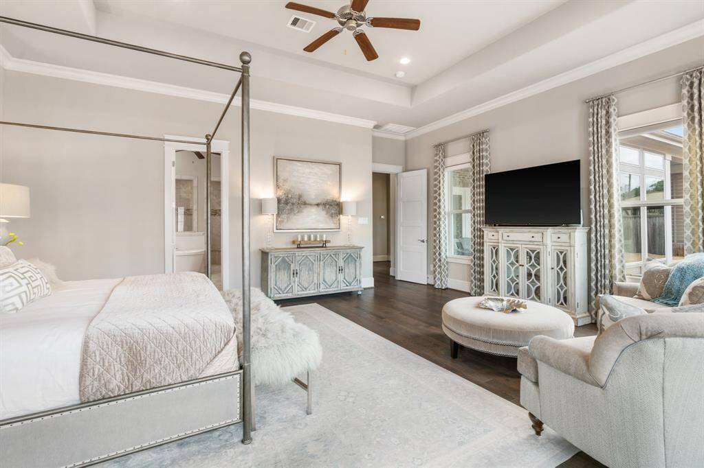 Elegance meets comfort in this inviting primary bedroom, featuring rich wood floors, a soothing neutral palette, and a charming vestibule entry that adds a touch of sophistication and privacy.