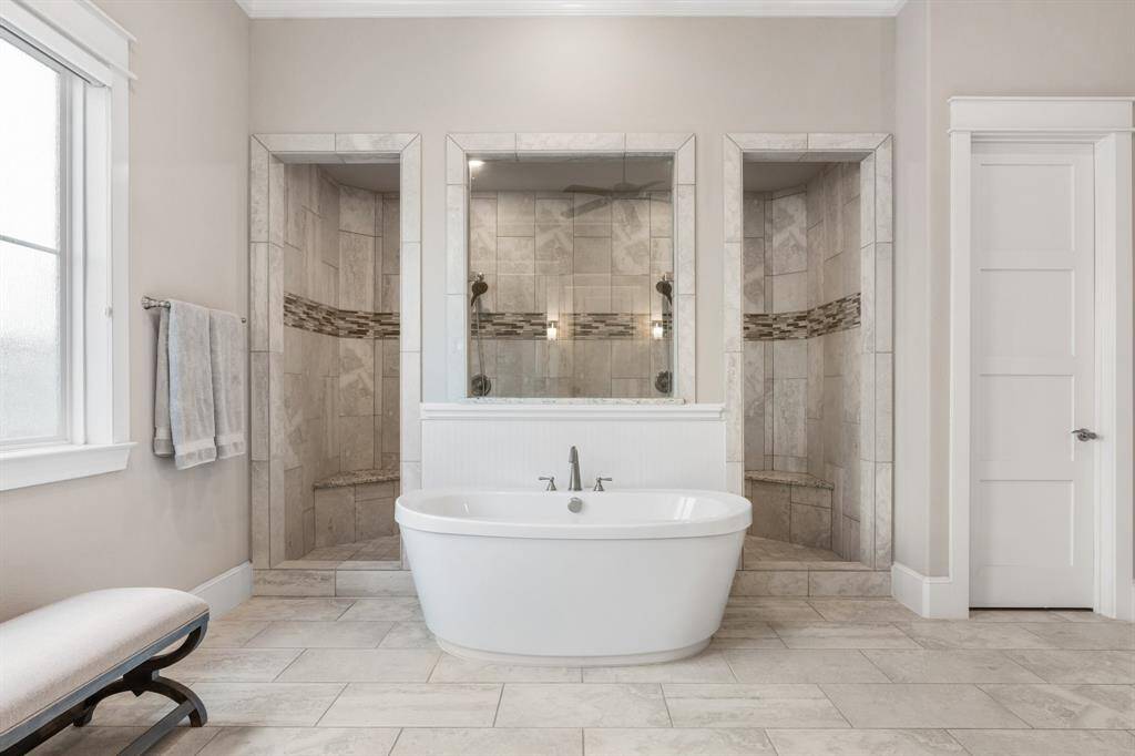 The perfect blend of style and relaxation are featured with a stand alone tub and walk through shower in the home's primary bath.