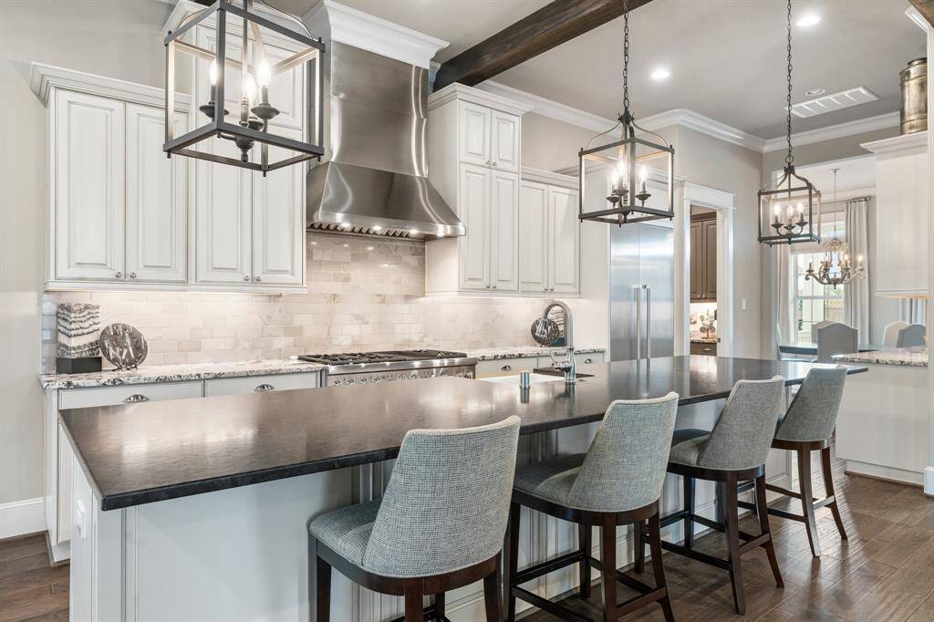 Upgraded cabinetry, countertops, backsplash, and designer lighting come together to create a stunning and functional kitchen.