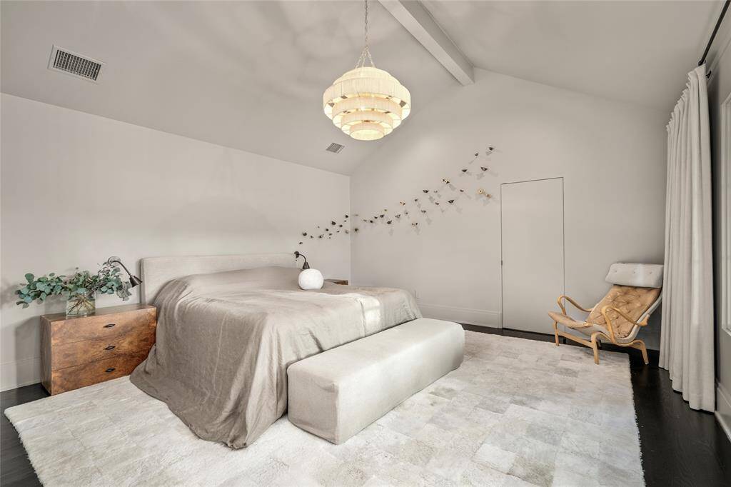 Primary Bedroom with vaulted ceiling, hidden tv mounting area (ready for Frame tv) behind the drapes, double closets and electrical switches on either side of bed.