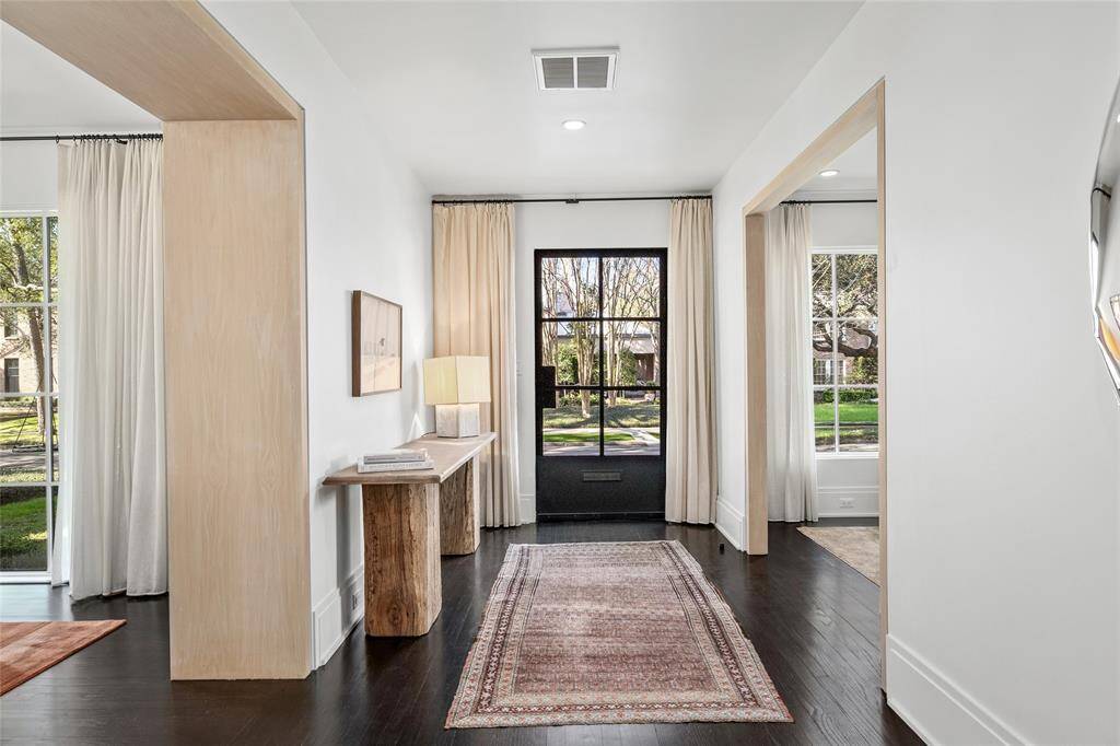 Front entry with a view of the cased openings, custom privacy drapes and the steel front door