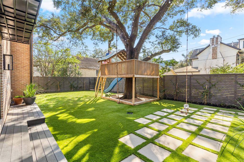 Large backyard with a gorgeous oak, turfed grass and custom treehouse