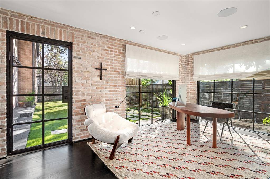 Office with exposed brick, expanded windows, steel doors, and built in filing cabinets and storage