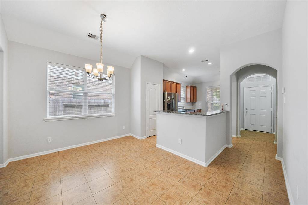 The kitchen features a convenient breakfast bar, perfect for quick meals or socializing, and a spacious pantry to keep everything organized.