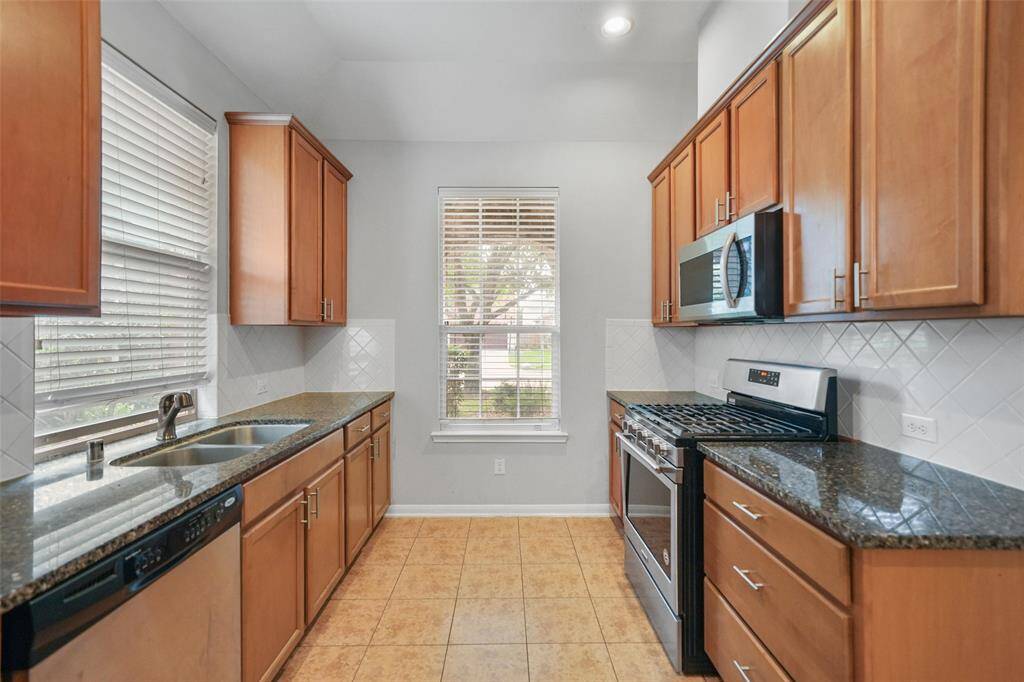 This galley-style kitchen features plenty of counter space for meal preparation and organization. With two windows bringing in natural light, the space feels bright and airy.