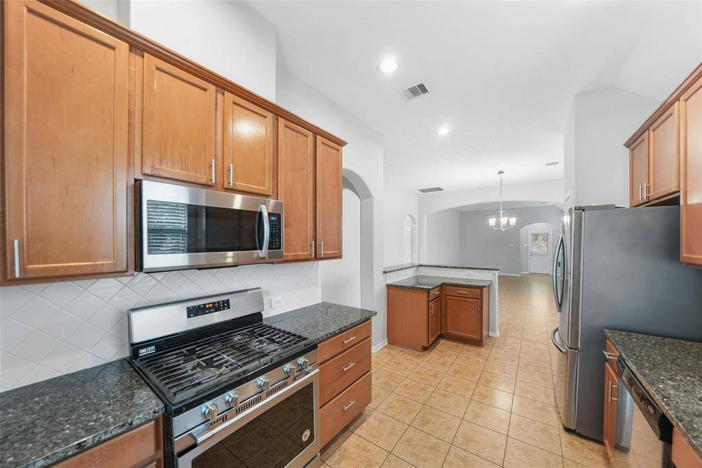 Cooking is a breeze in this kitchen with a gas oven and range, plus a stainless steel built-in microwave for added convenience.
