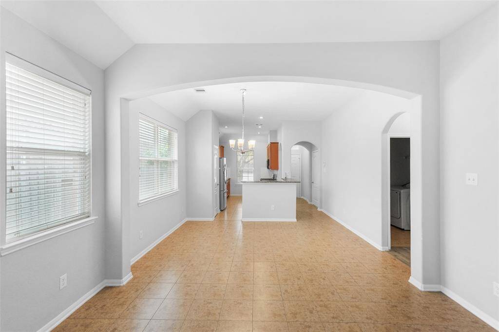 Additional view of the living area; the beautiful arched doorways and soaring vaulted ceiling make this living room feel open and inviting.