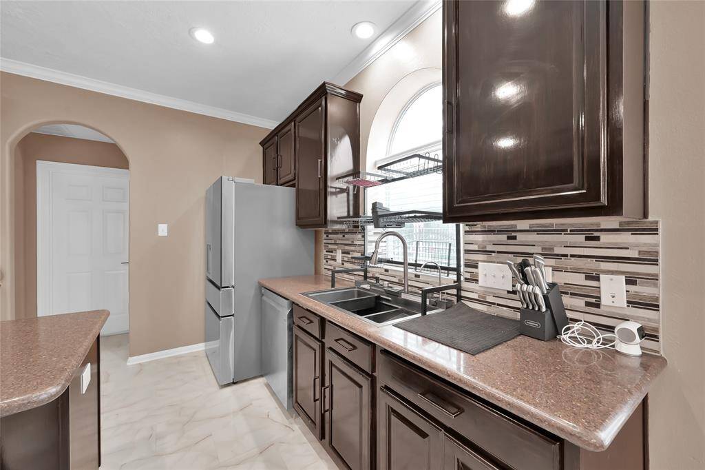 Step on up to the modern Lefton Waterwall sink with temperature display and LED lighting. Beyond the kitchen is the laundry room