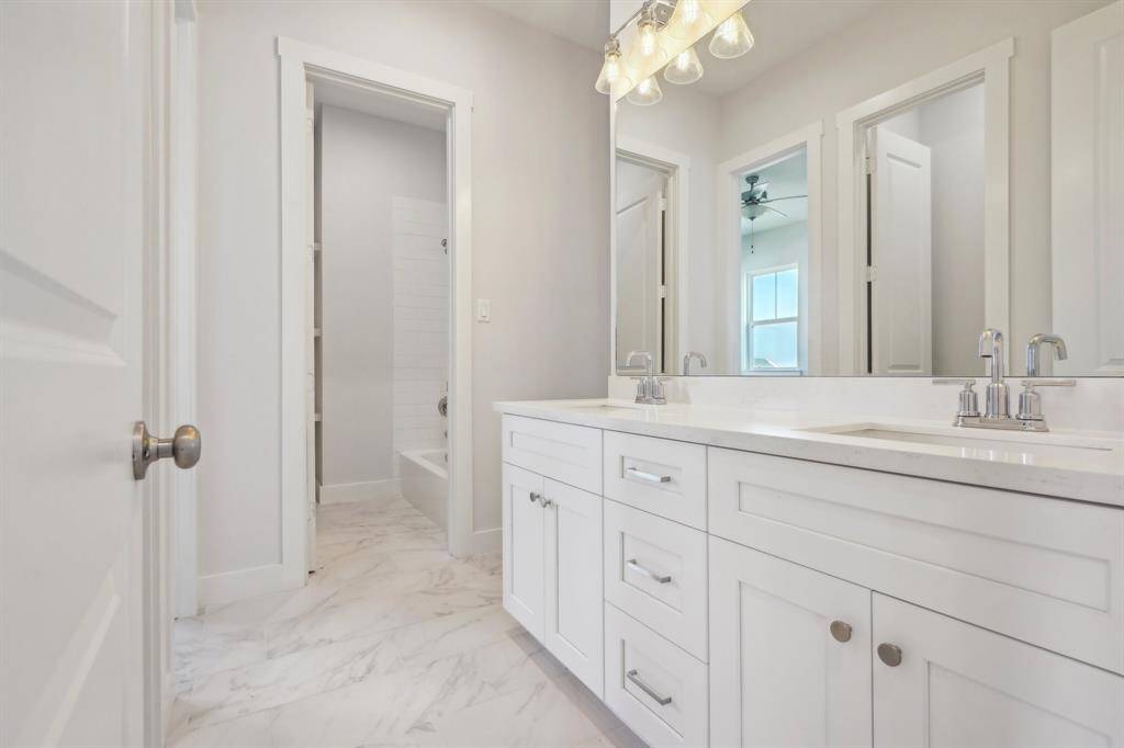 Dual vanities with quartz counters opens to the guest as well as the 3rd guest bedroom.