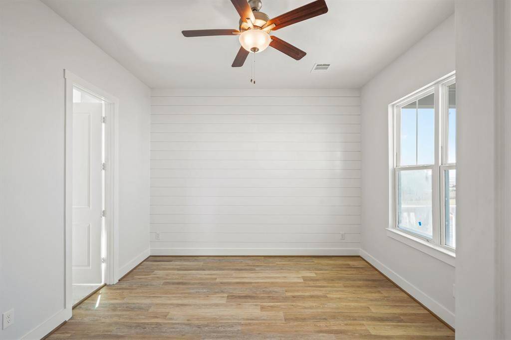 The primary bedroom features bay views, and a shiplap accent wall.