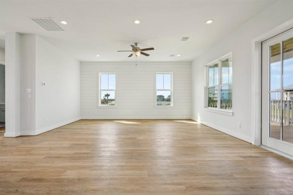 The living room opens up to a bright, sunlit space and features a striking shiplap accent wall.